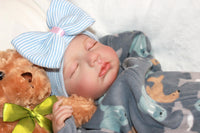 Thumbnail for A cute baby in a bow, cuddling a teddy bear, embodying warmth and playfulness.