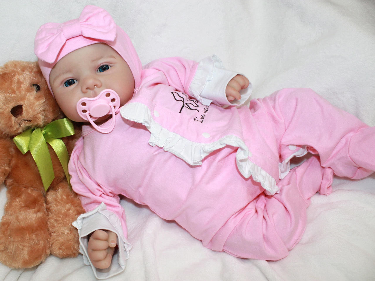 A baby doll positioned on a bed alongside a teddy bear, symbolizing innocence and the joy of playtime.