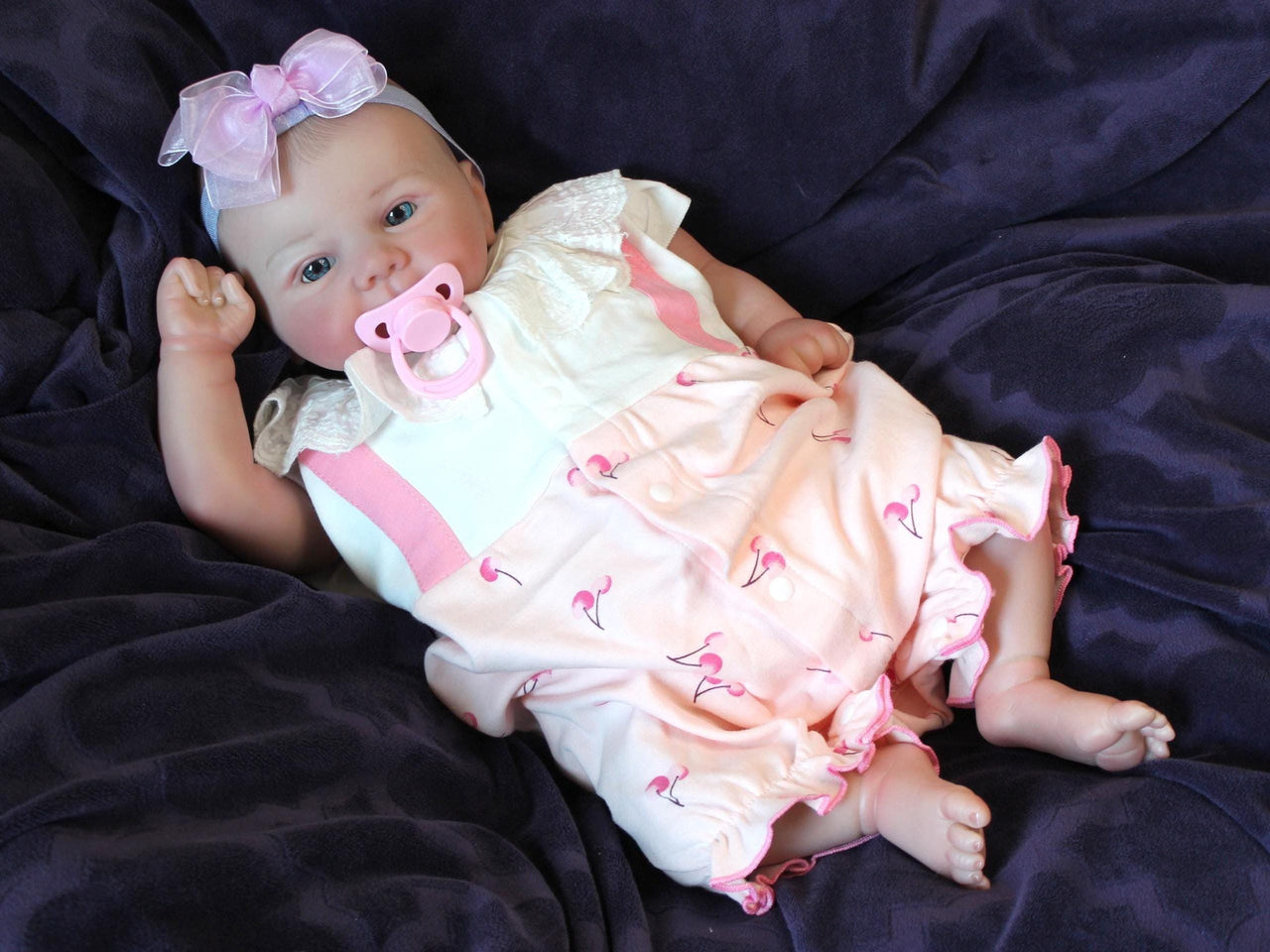 A baby doll resting on a bed, creating a cozy and playful scene.