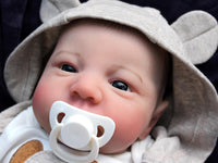 Thumbnail for An infant wearing a hat, comfortably resting on a colorful blanket, exuding a sense of tranquilit
