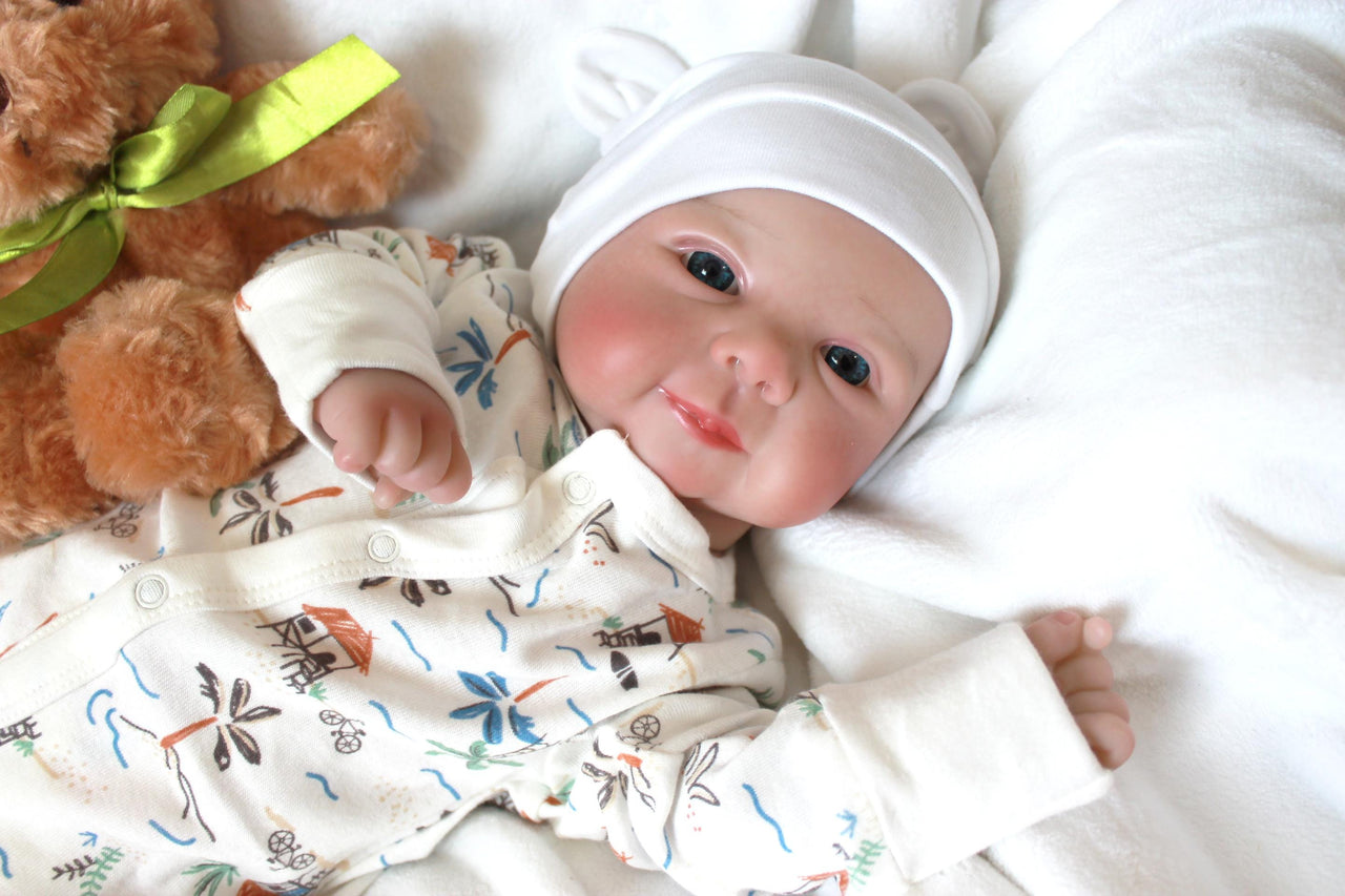 A baby doll positioned on a bed alongside a teddy bear, symbolizing innocence and the joy of playtime.