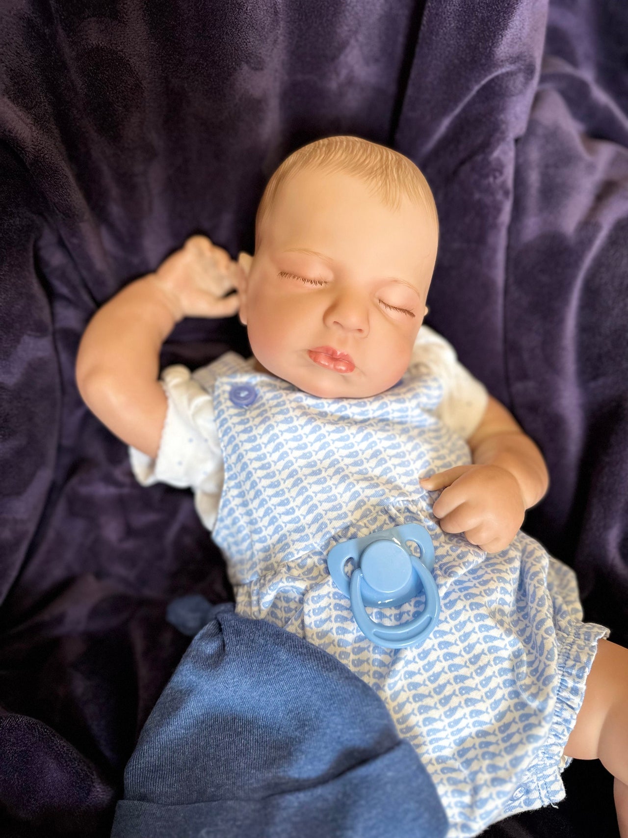 Realistic 20-inch reborn baby doll with closed eyes, blue hat, romper, and socks – lifelike sleeping newborn doll for gifting and collecting