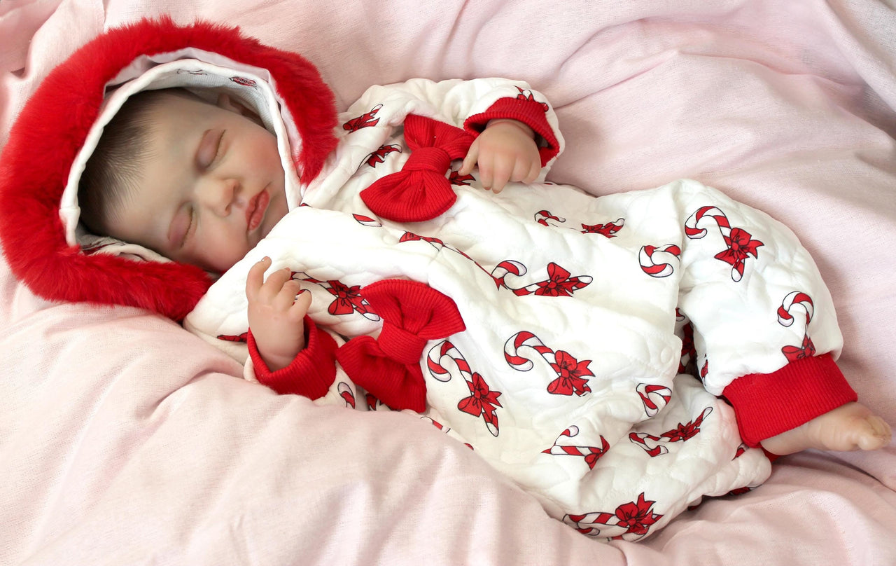 reborn doll in a red and white candy cane outfit with a furry red hood