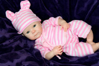 Thumbnail for A baby doll dressed in a pink and white striped outfit, sitting upright with a cheerful expression.