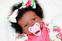 Thumbnail for A black baby doll positioned on a white bed, highlighting its charming design against a clean, bright background.