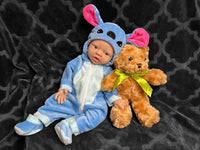 Thumbnail for A baby doll wearing a blue outfit, featuring a cute expression and soft, plush material.