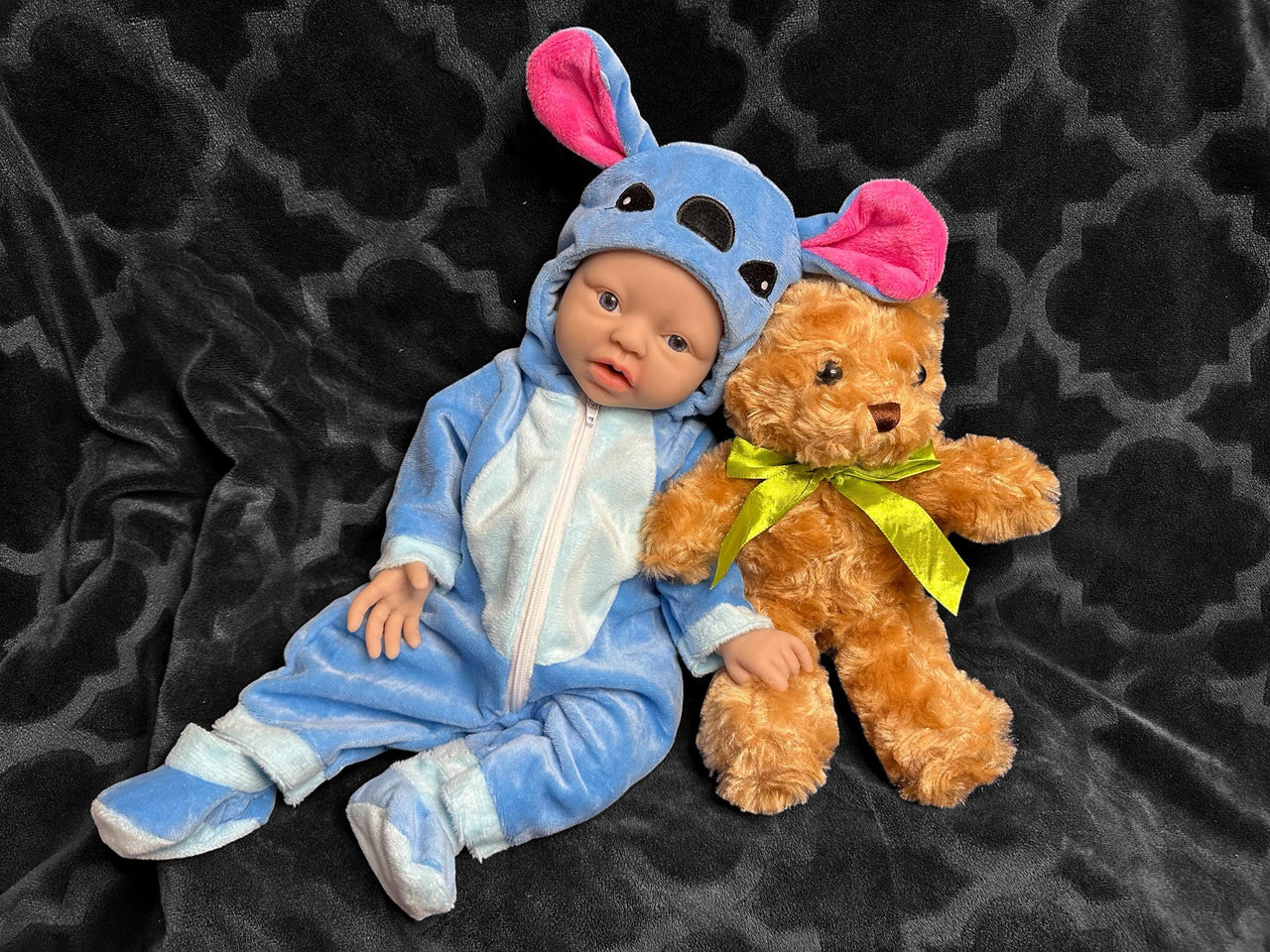 A baby doll wearing a blue outfit, featuring a cute expression and soft, plush material.