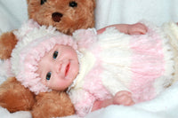 Thumbnail for A plush teddy bear is positioned next to a baby doll, showcasing a charming display of childhood toys.