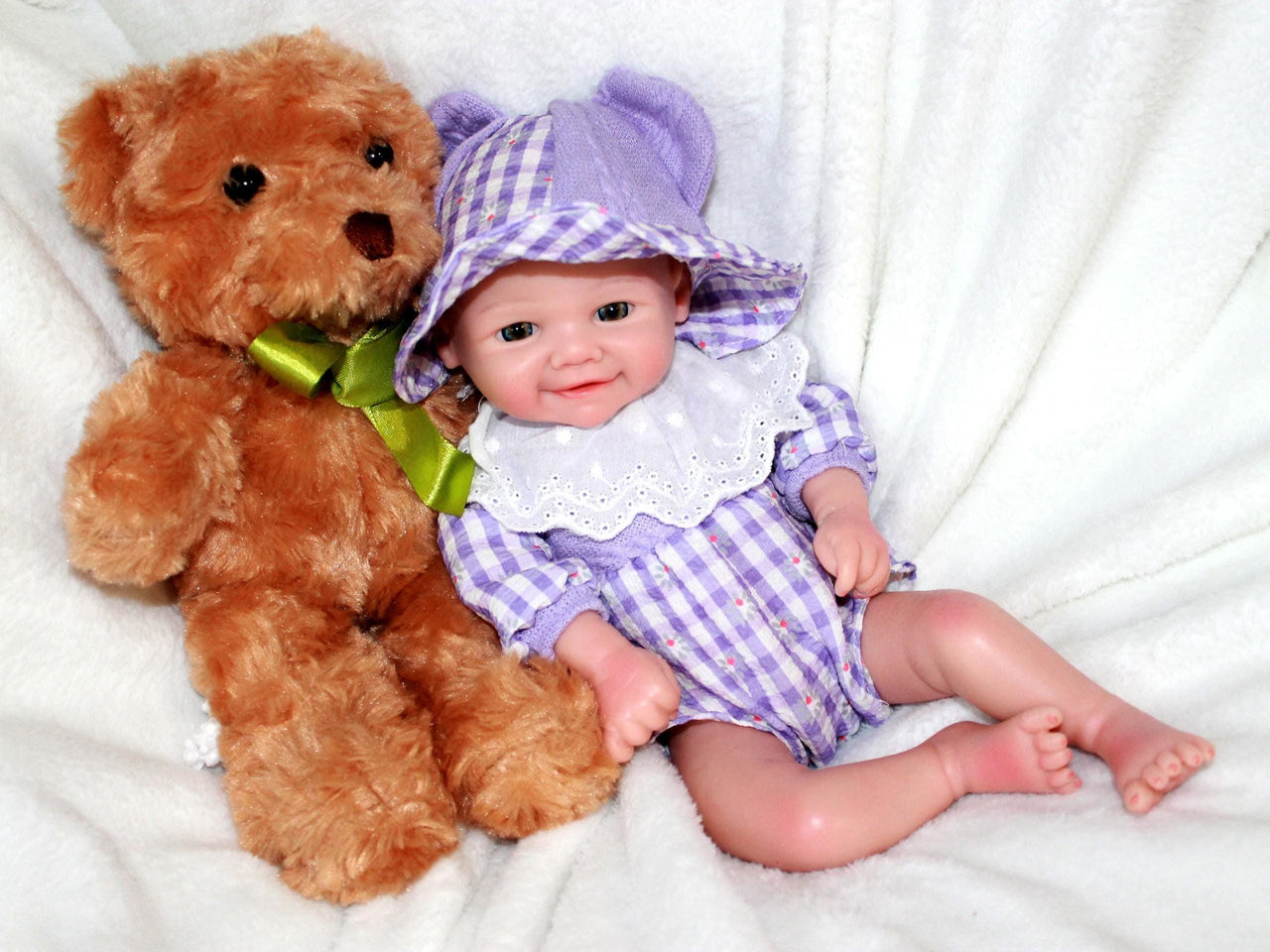 A baby doll dressed in a purple and white dress, featuring a sweet expression and soft, lifelike features.