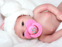 Thumbnail for A baby doll with a pacifier rests on a soft blanket, showcasing its cute features and gentle expression.