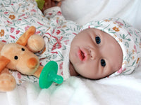 Thumbnail for A baby doll resting on a bed beside a soft stuffed animal, creating a cozy and playful scene.