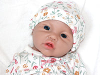 Thumbnail for A baby doll resting on a bed beside a soft stuffed animal, creating a cozy and playful scene.