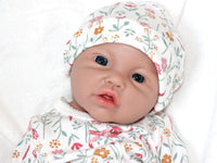 Thumbnail for A baby doll resting on a bed beside a soft stuffed animal, creating a cozy and playful scene.