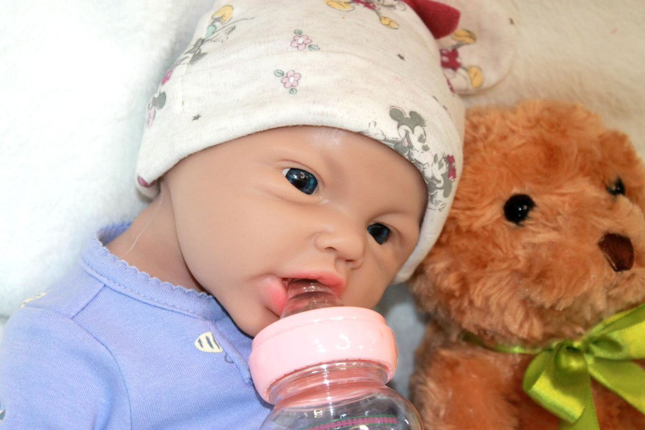A baby doll is positioned on a blanket with a teddy bear, symbolizing innocence and the joy of playtime.