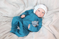 Thumbnail for A baby wearing a blue outfit is comfortably lying on a blanket, surrounded by a serene atmosphere.