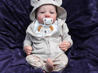 Thumbnail for An infant wearing a hat, comfortably resting on a colorful blanket, exuding a sense of tranquilit