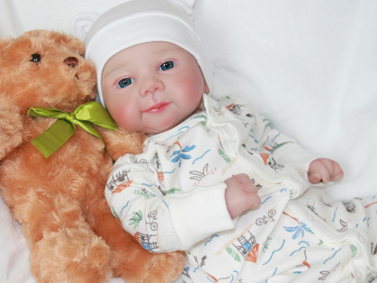 A baby doll positioned on a clean white sheet, highlighting its charming design and soft textures.