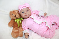 Thumbnail for A baby doll positioned on a clean white sheet, highlighting its charming design and soft textures.