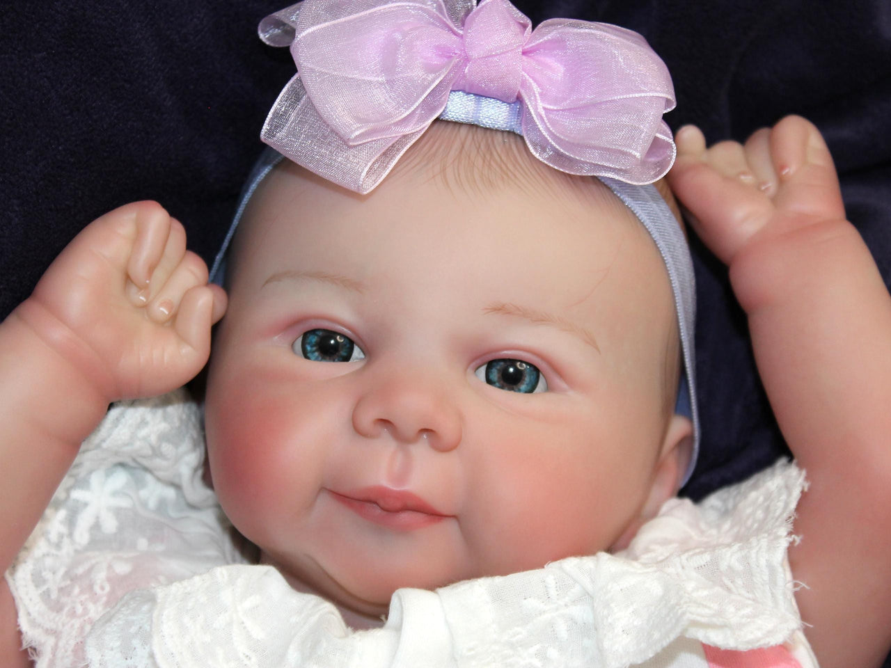 A baby doll lies on a purple blanket, evoking a sense of comfort and childhood innocence.