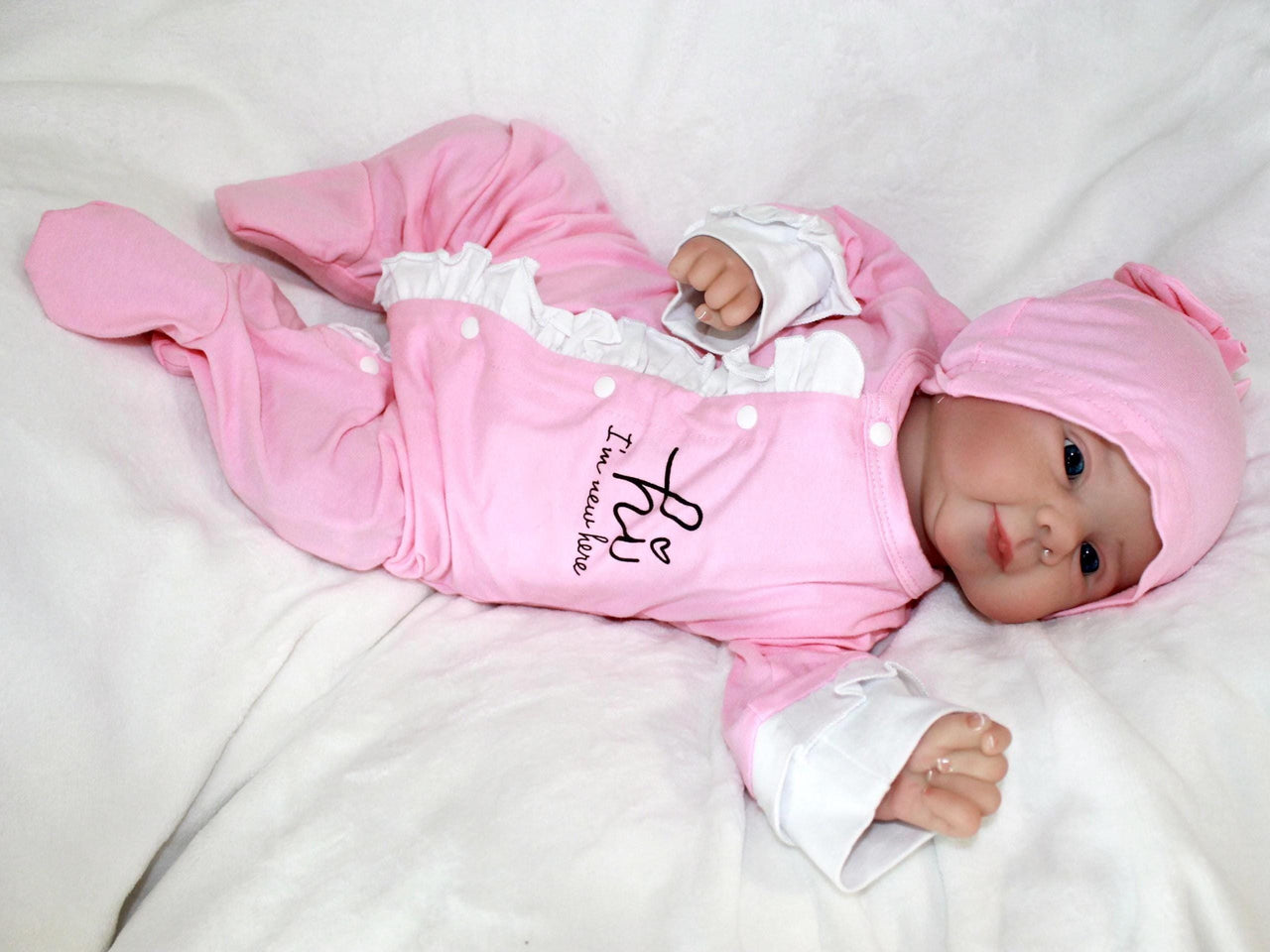 A baby doll lies on a white blanket, evoking a sense of comfort and childhood innocence.