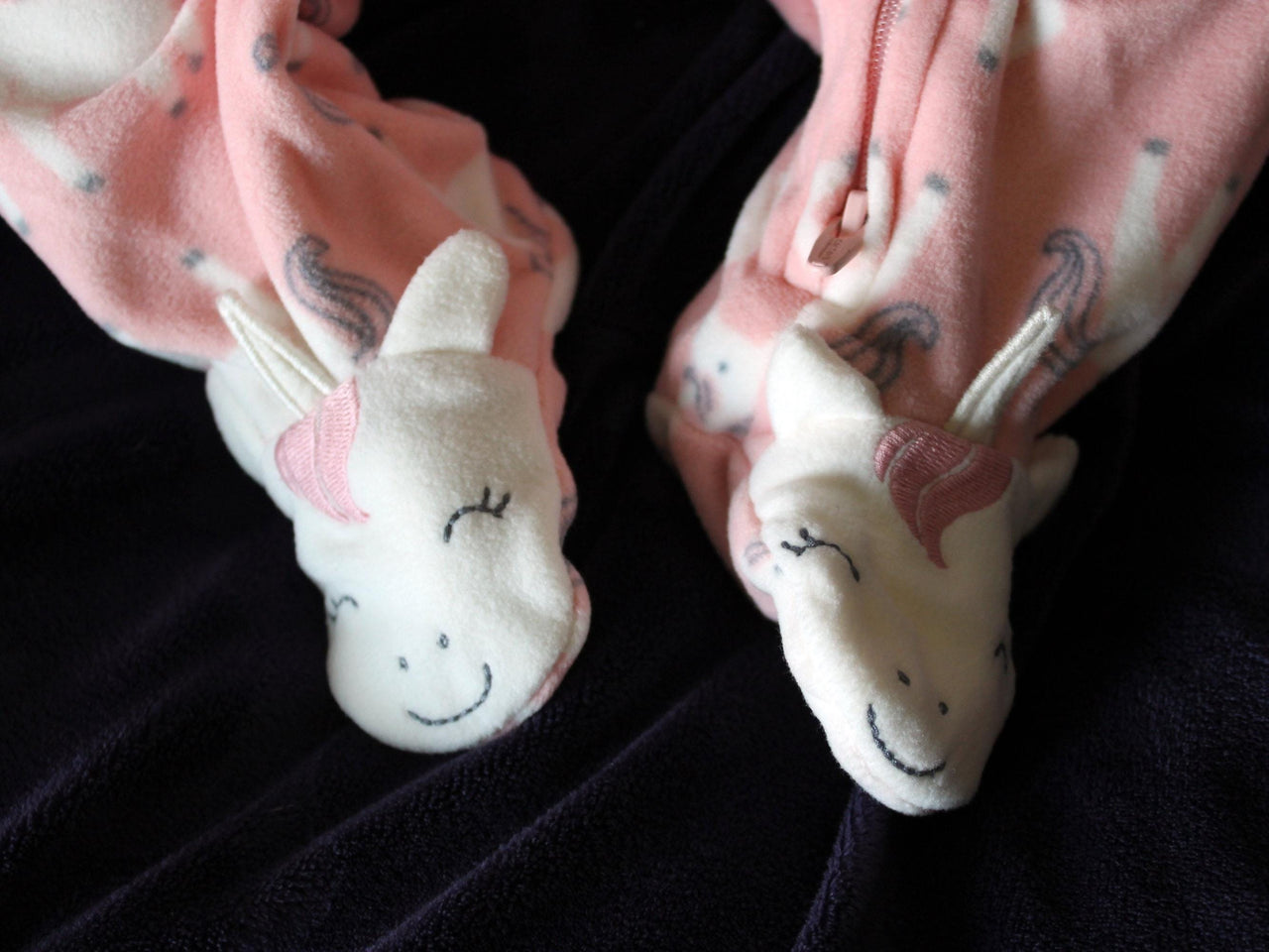 A baby doll positioned on a plush purple couch, highlighting its charming feet and vibrant outfit.