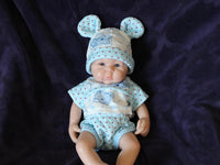 Thumbnail for Lifelike reborn baby doll with blue eyes wearing blue bear-print outfit and matching bunny ear hat, realistic handmade newborn doll