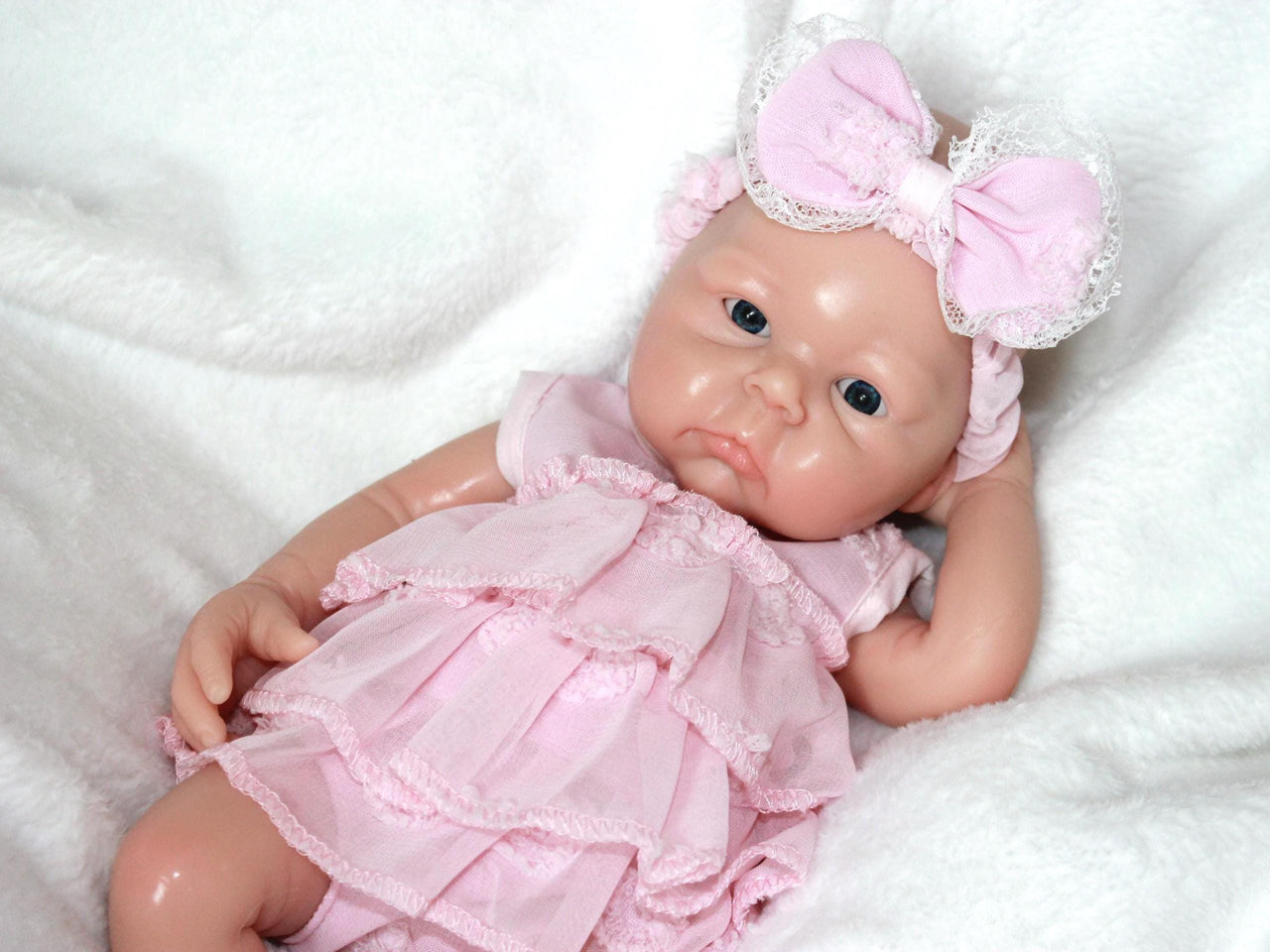 Handmade reborn baby doll in pink frilly dress, realistic vinyl newborn with headband and socks, therapy or collectible lifelike doll