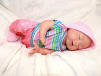 Thumbnail for Sleeping reborn silicone baby doll wearing pink knit hat, striped shirt, and pink pants, lifelike 13-inch newborn doll on white blanket