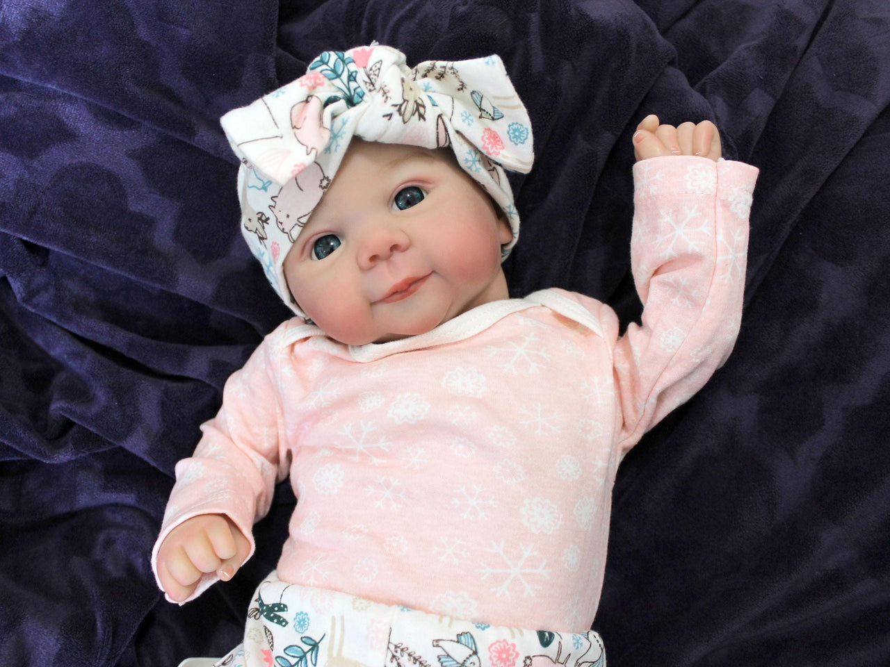 A baby doll resting on a bed beside, creating a cozy and playful scene.