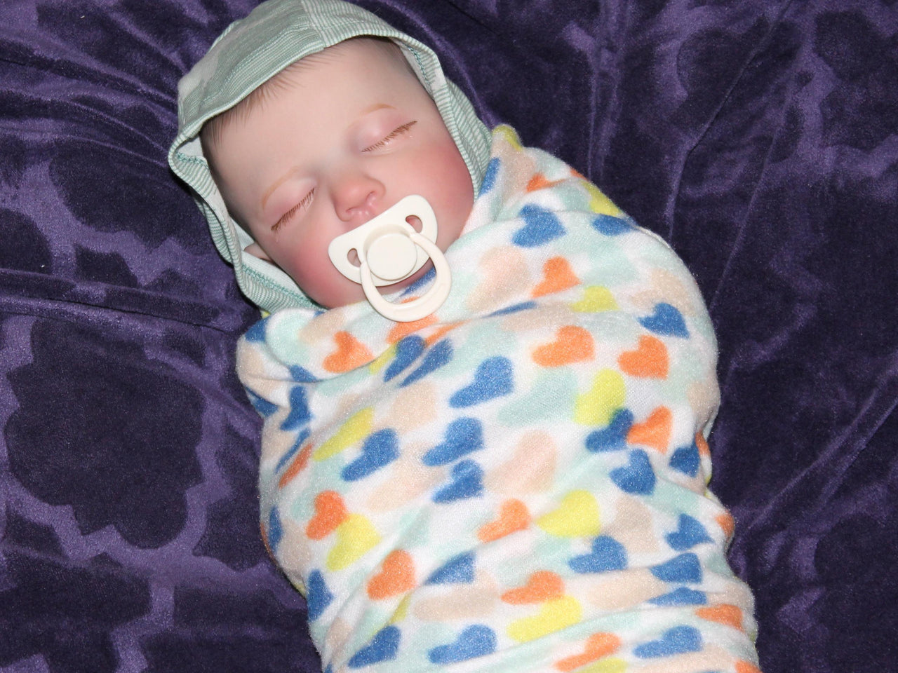 A peaceful baby sleeping soundly, wrapped snugly in a soft blanket.