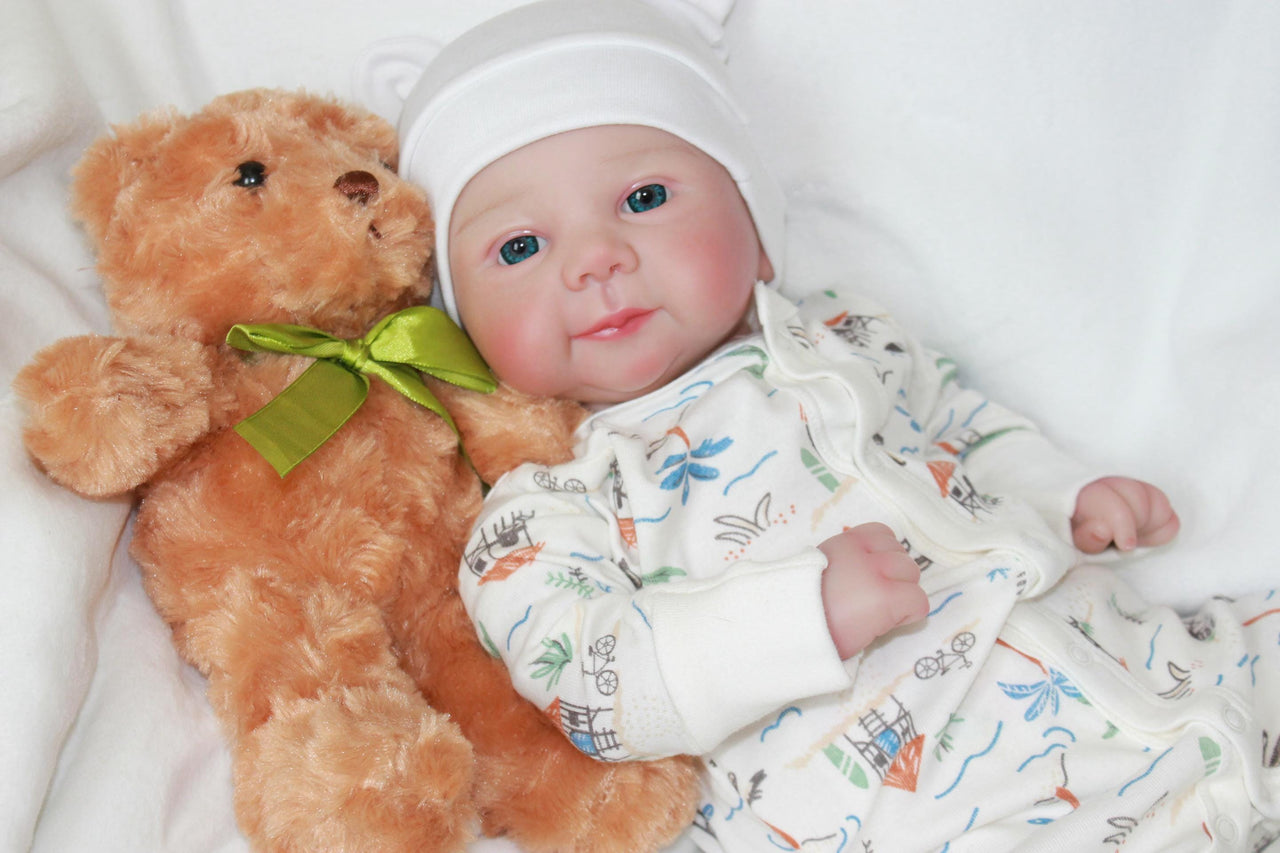 A baby doll lies on a bed next to a teddy bear, evoking a sense of childhood comfort and companionship.