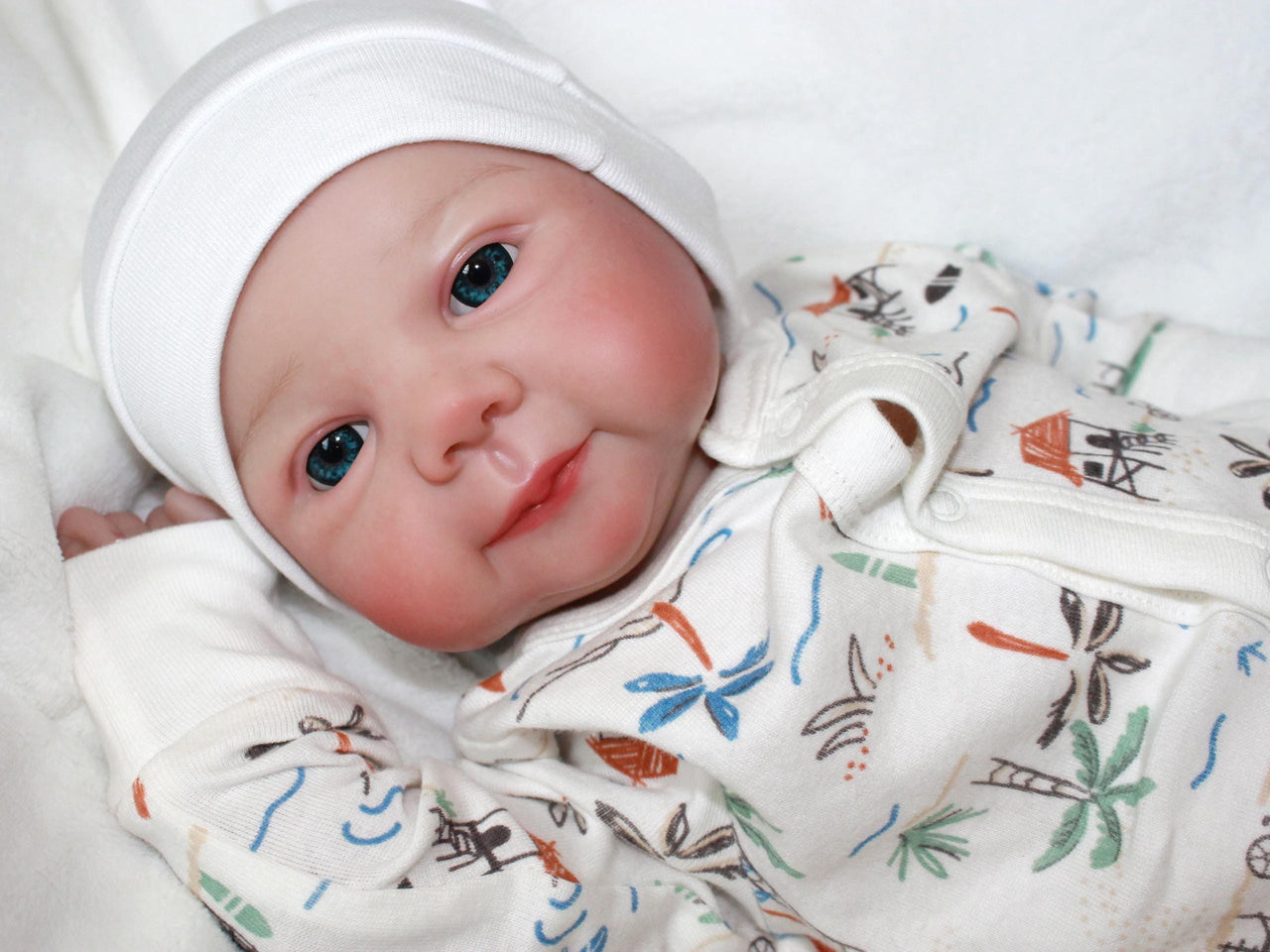 A baby doll lies on a white blanket, evoking a sense of comfort and childhood innocence.