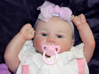 Thumbnail for A baby doll lies on a purple blanket, evoking a sense of comfort and childhood innocence.