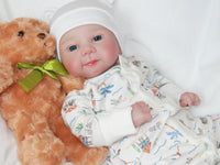 Thumbnail for A baby doll lying on a pristine white sheet, emphasizing its adorable appearance and gentle colors.