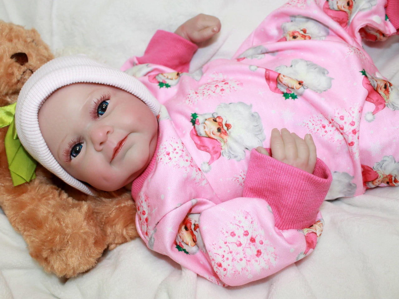 A baby dressed in pink cuddles a teddy bear, exuding joy and innocence.