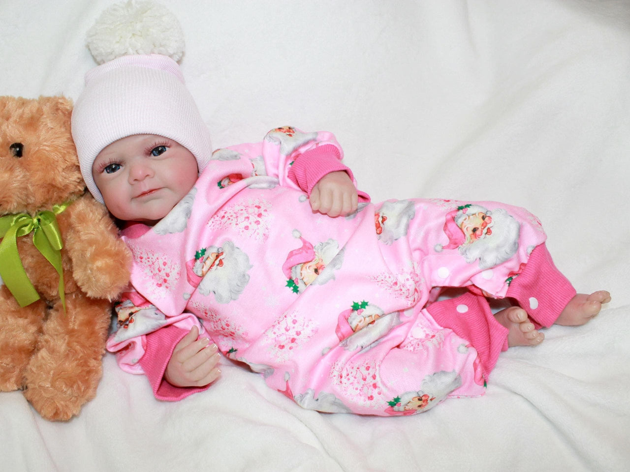 A baby dressed in pink cuddles a teddy bear, exuding joy and innocence.