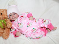 Thumbnail for A baby dressed in pink cuddles a teddy bear, exuding joy and innocence.