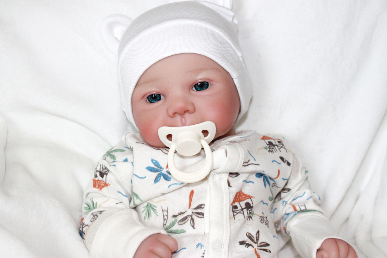 A baby doll lies on a bed, evoking a sense of childhood comfort and companionship.