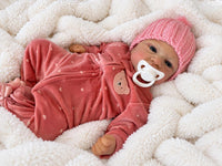 Thumbnail for A baby doll with a pacifier lies on a cozy blanket, highlighting its charming design and soothing presence.